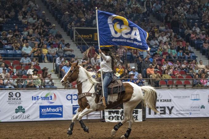Horse rider holding an ASU flag at the rodeo