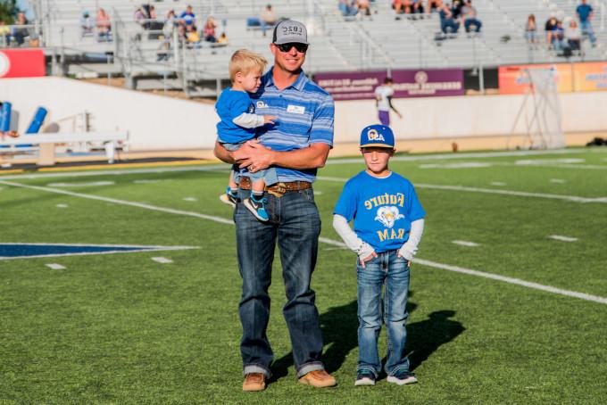Homecoming honorees with his kids on the football field